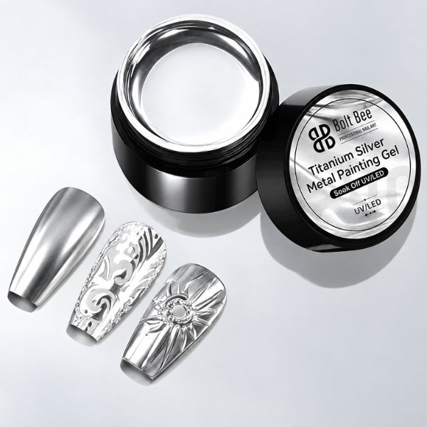 Three metallic silver artificial nail tips displayed next to an open jar of Bolt Bee Titanium Silver Metal Painting Gel on a light gray background. USE IN NAIL ART EXTENTION