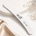 SUZI nail file with a white textured surface, BANANA shape, rounded ends and printed 100/180 grit marking.