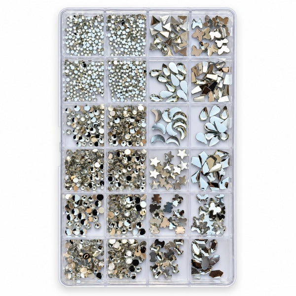 A clear plastic organizer tray filled with assorted rhinestone and metallic nail art embellishments in silver, white, and champagne tones, photographed on a plain white background. FOR NAIL ART USE